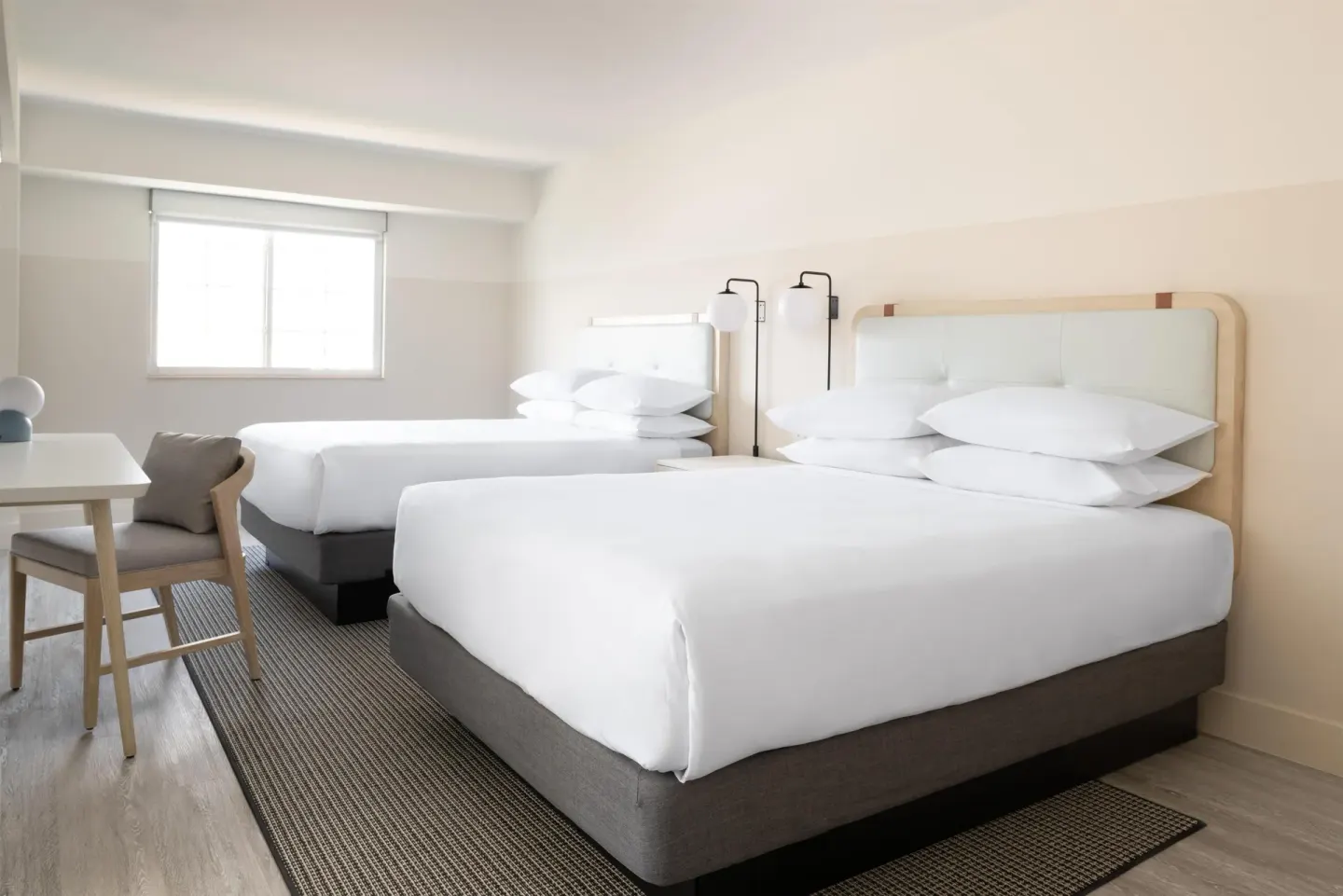 Studio room with two beds and work table at Hampton by Hilton Grand Cayman Seven Mile Beach.