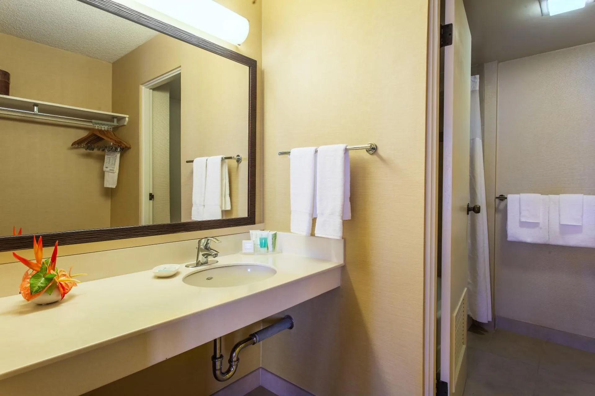 Suite bathroom vanity with mirror and towels at Hilo Hawaiian Hotel.