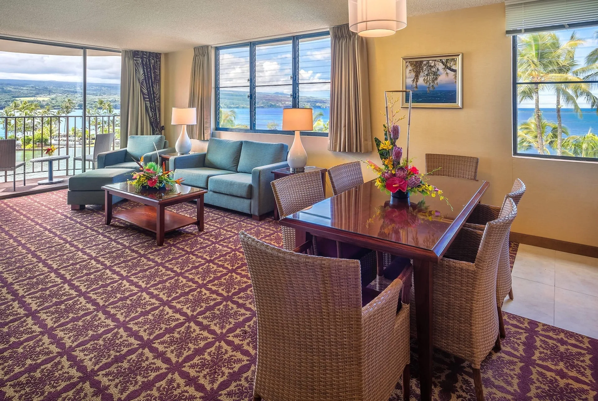Oceanfront suite living and dining area with balcony views at Hilo Hawaiian Hotel.
