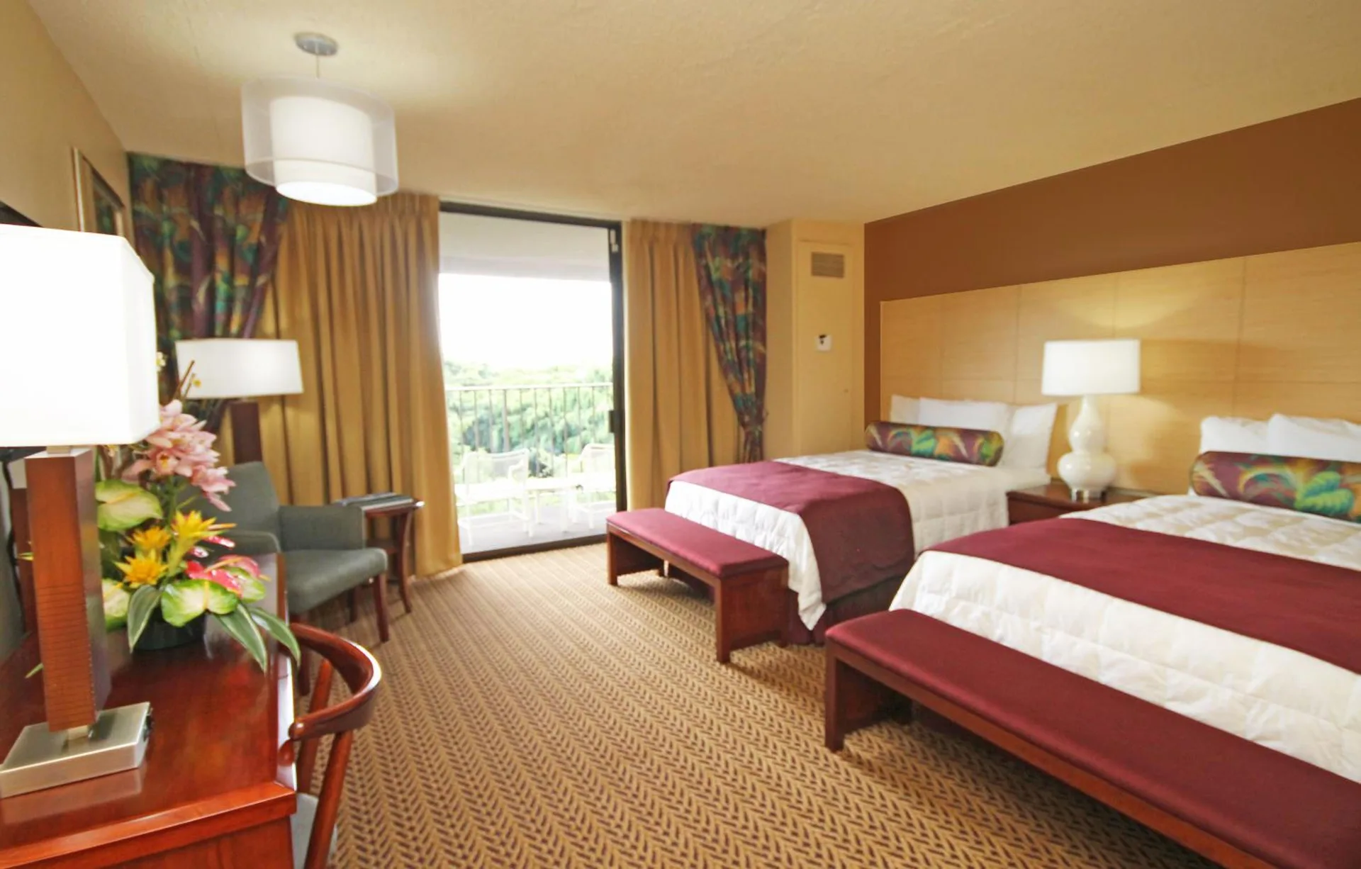 Oceanfront suite bedroom with two beds and balcony light at Hilo Hawaiian Hotel.