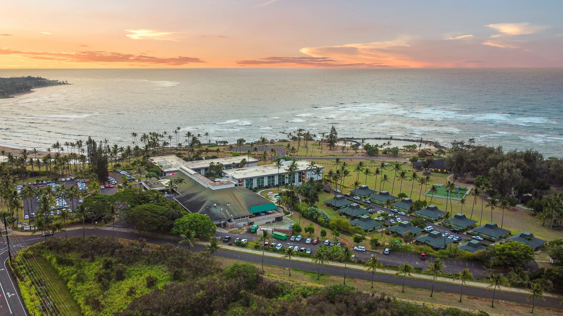 Aerial sunset view of the oceanfront grounds at Hilton Garden Inn Kauai Wailua Bay.