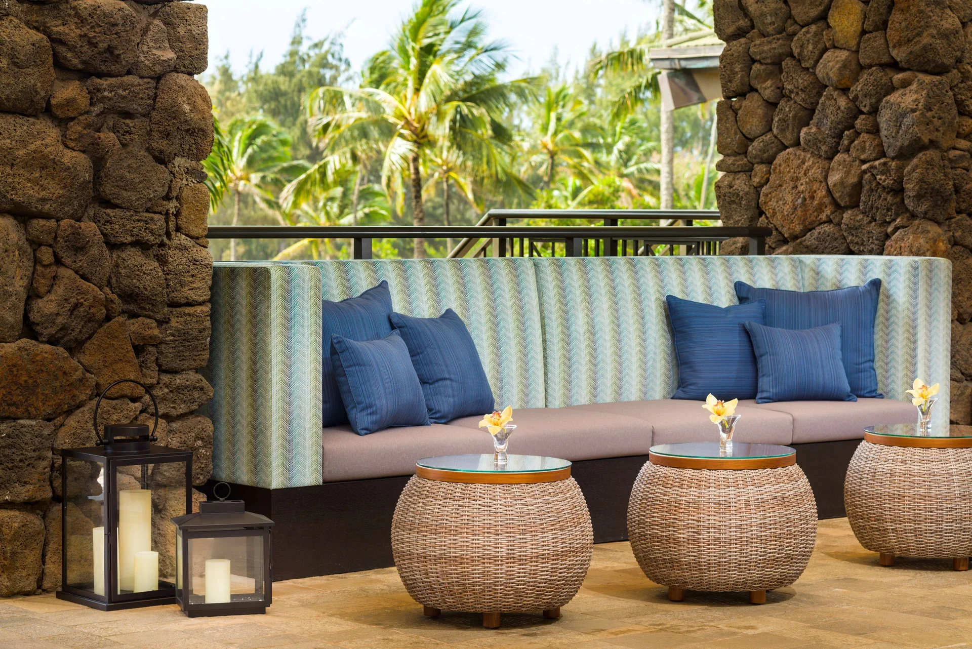 Covered lounge seating with blue pillows at Hilton Garden Inn Kauai Wailua Bay.