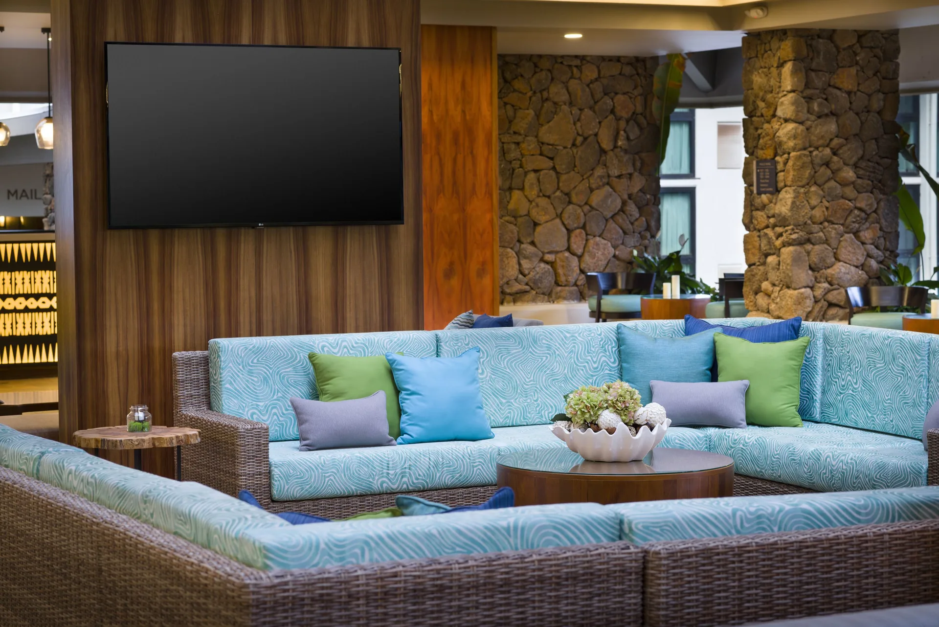 Lobby lounge with turquoise sectional seating at Hilton Garden Inn Kauai Wailua Bay.