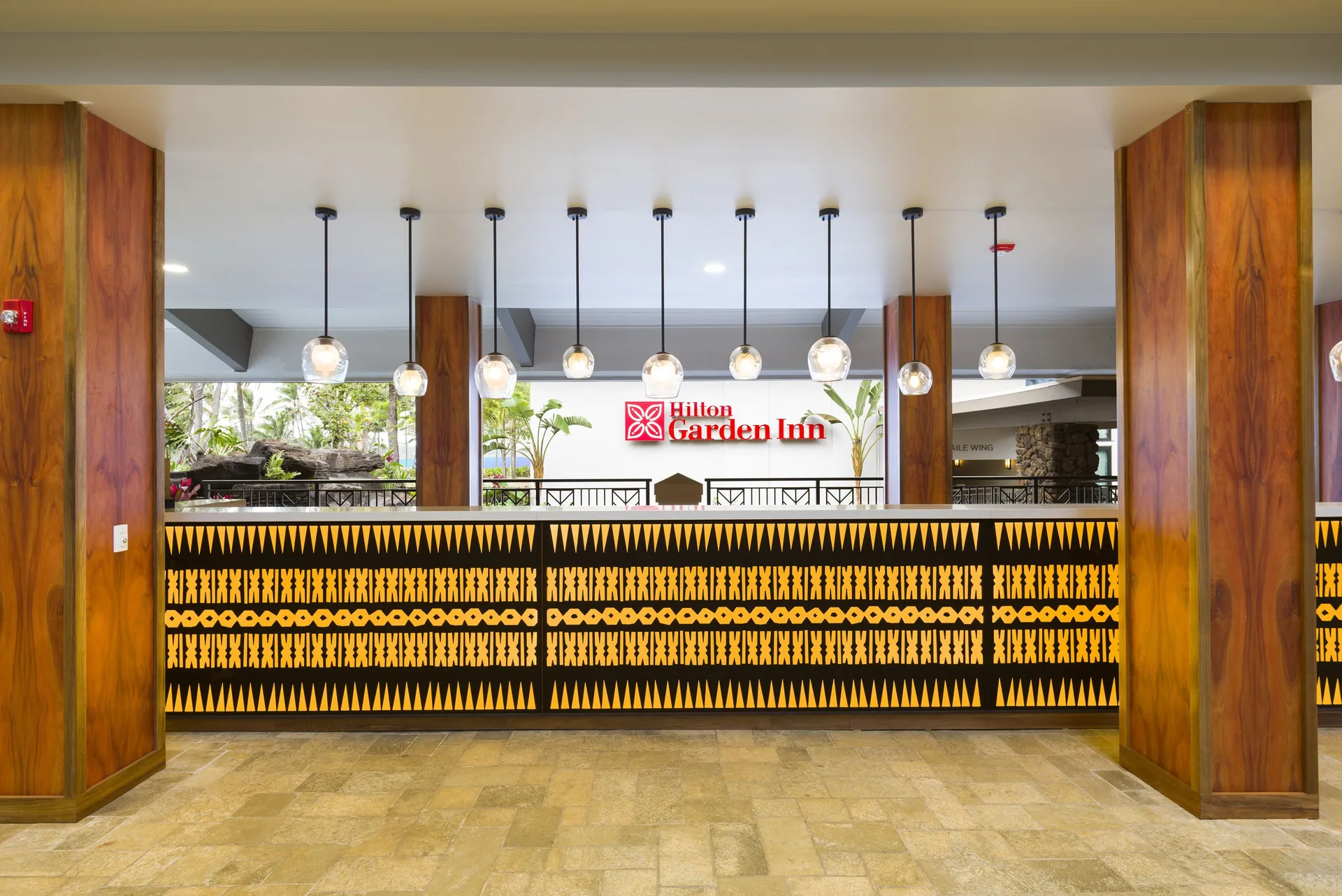 Lobby reception desk with patterned screen at Hilton Garden Inn Kauai Wailua Bay.