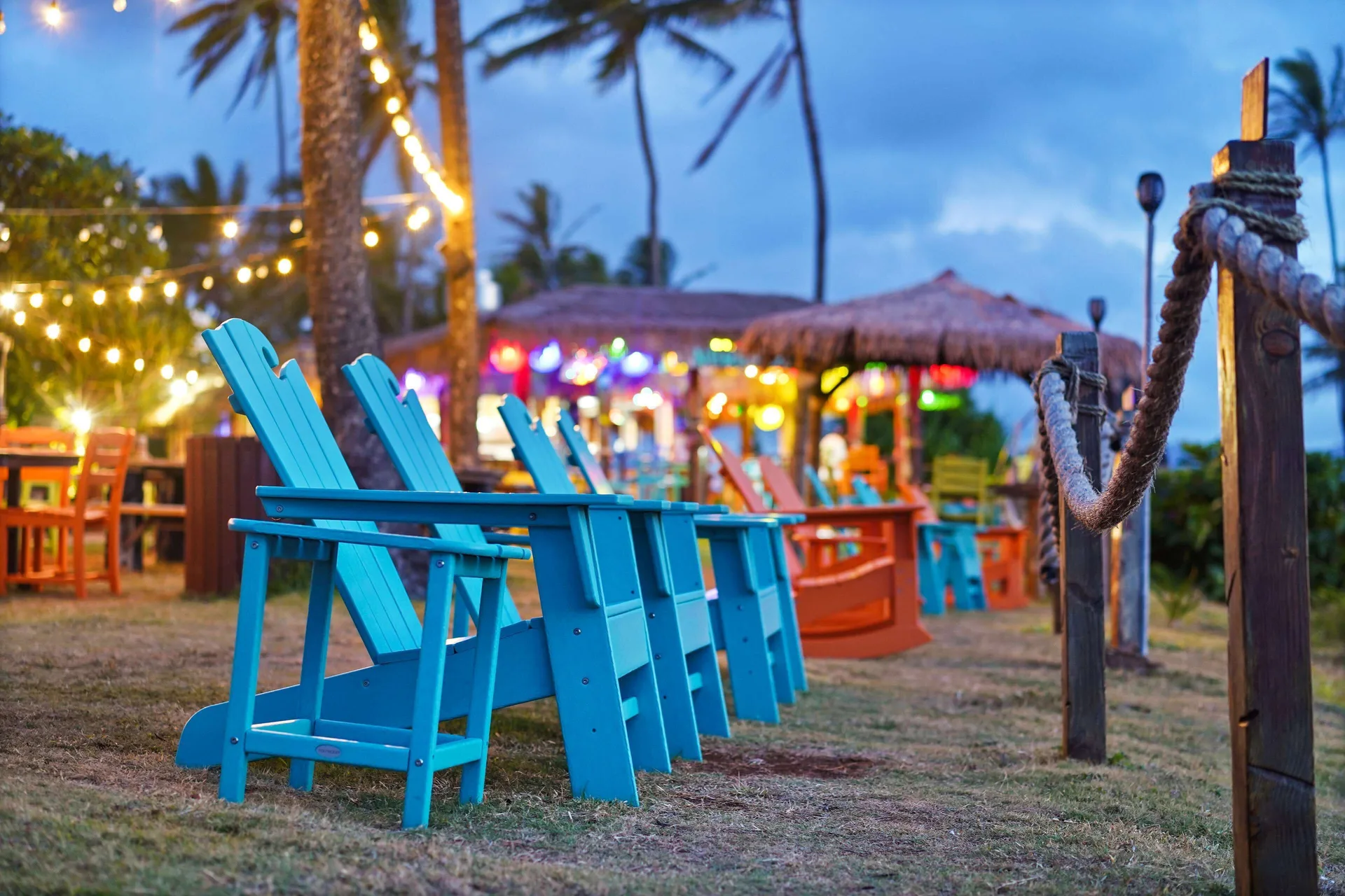 Colorful outdoor lounge chairs under string lights at Hilton Garden Inn Kauai Wailua Bay.
