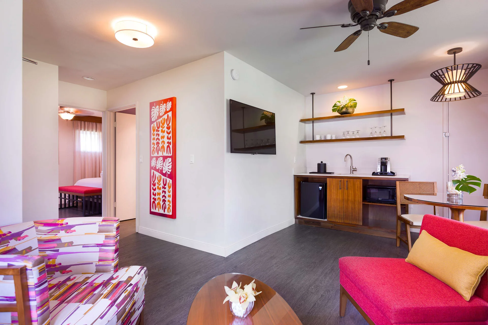 Cottage living area with seating, kitchenette, and bedroom doorway at Hilton Garden Inn Kauai Wailua Bay.