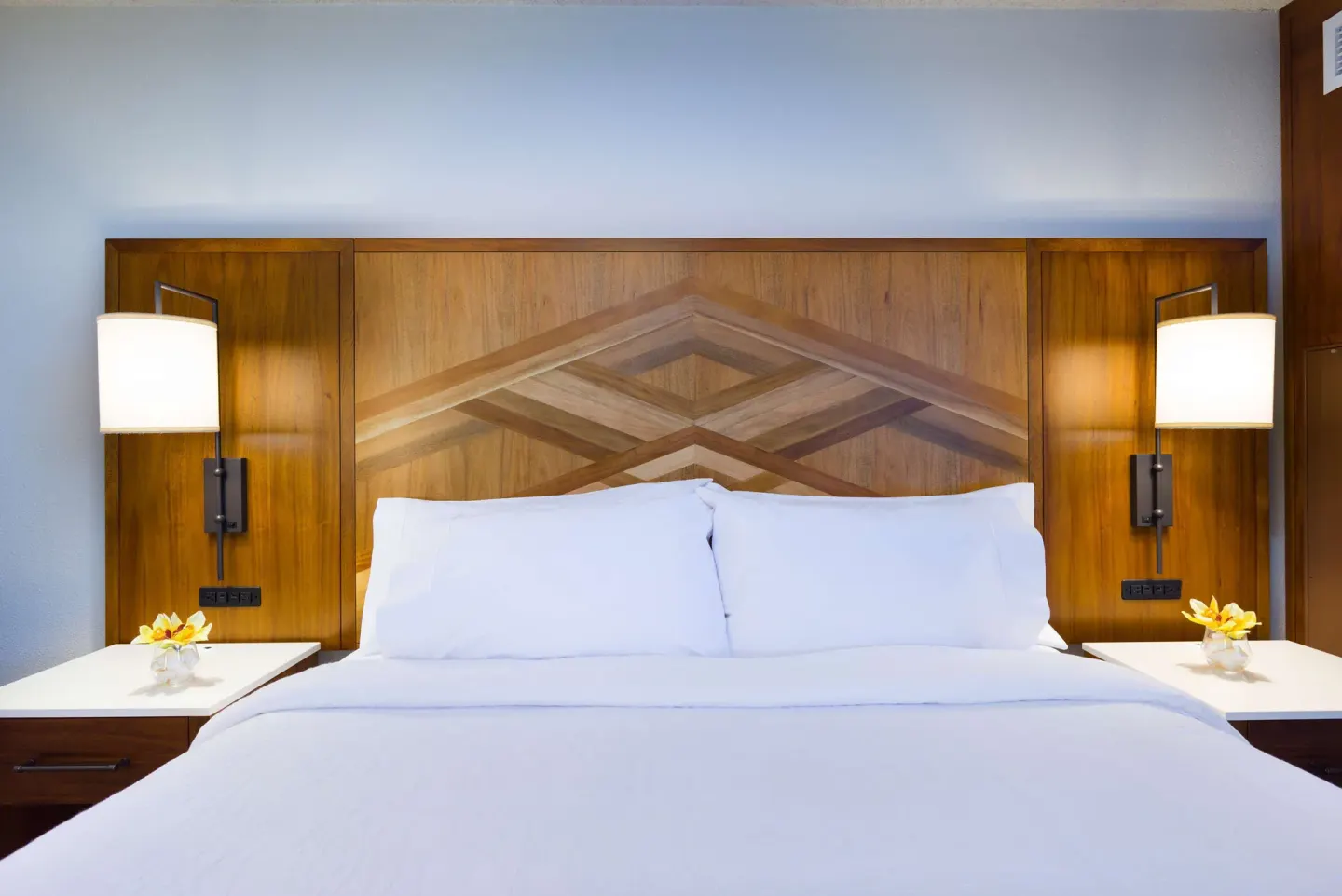 Accessible room king bed with wood headboard at Hilton Garden Inn Kauai Wailua Bay.