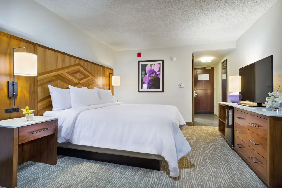 Accessible room king bed with dresser and TV at Hilton Garden Inn Kauai Wailua Bay.