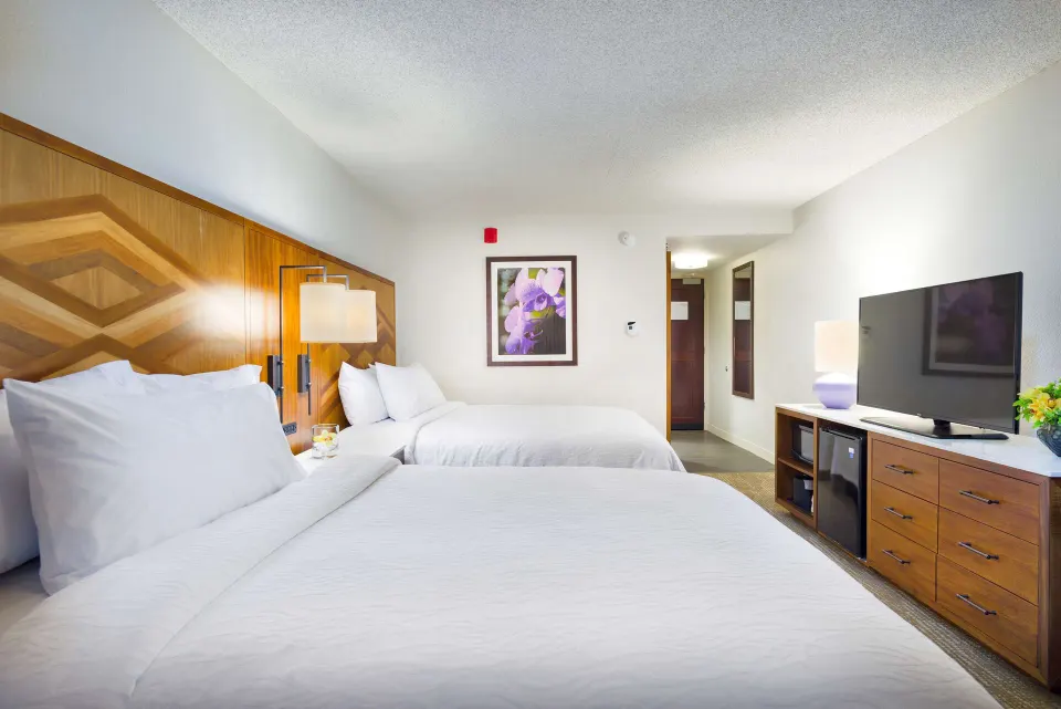 Ocean view room with two beds and TV at Hilton Garden Inn Kauai Wailua Bay.