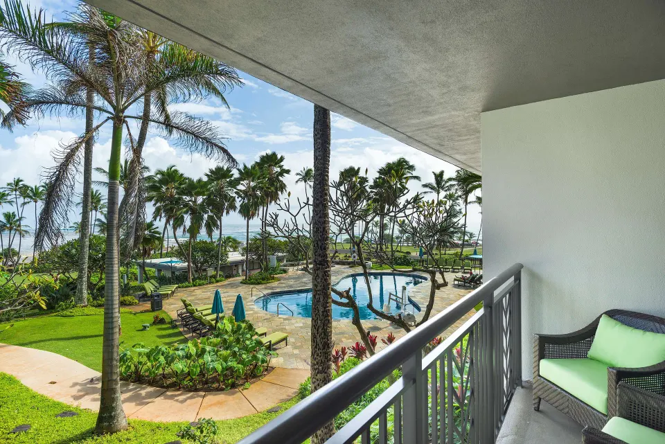 Accessible suite balcony overlooking the pool and ocean at Hilton Garden Inn Kauai Wailua Bay.