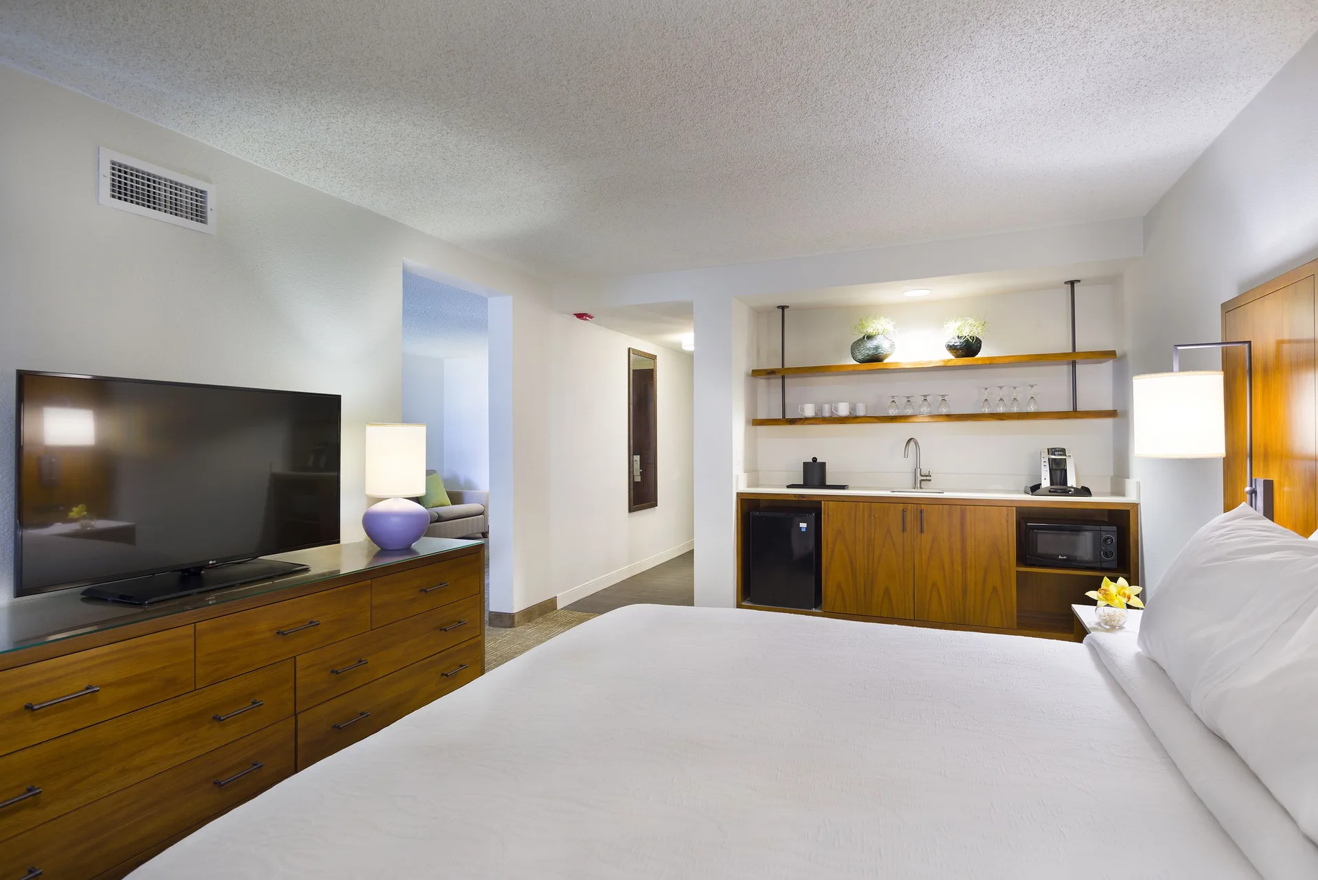 Accessible suite bedroom with king bed and wet bar at Hilton Garden Inn Kauai Wailua Bay.