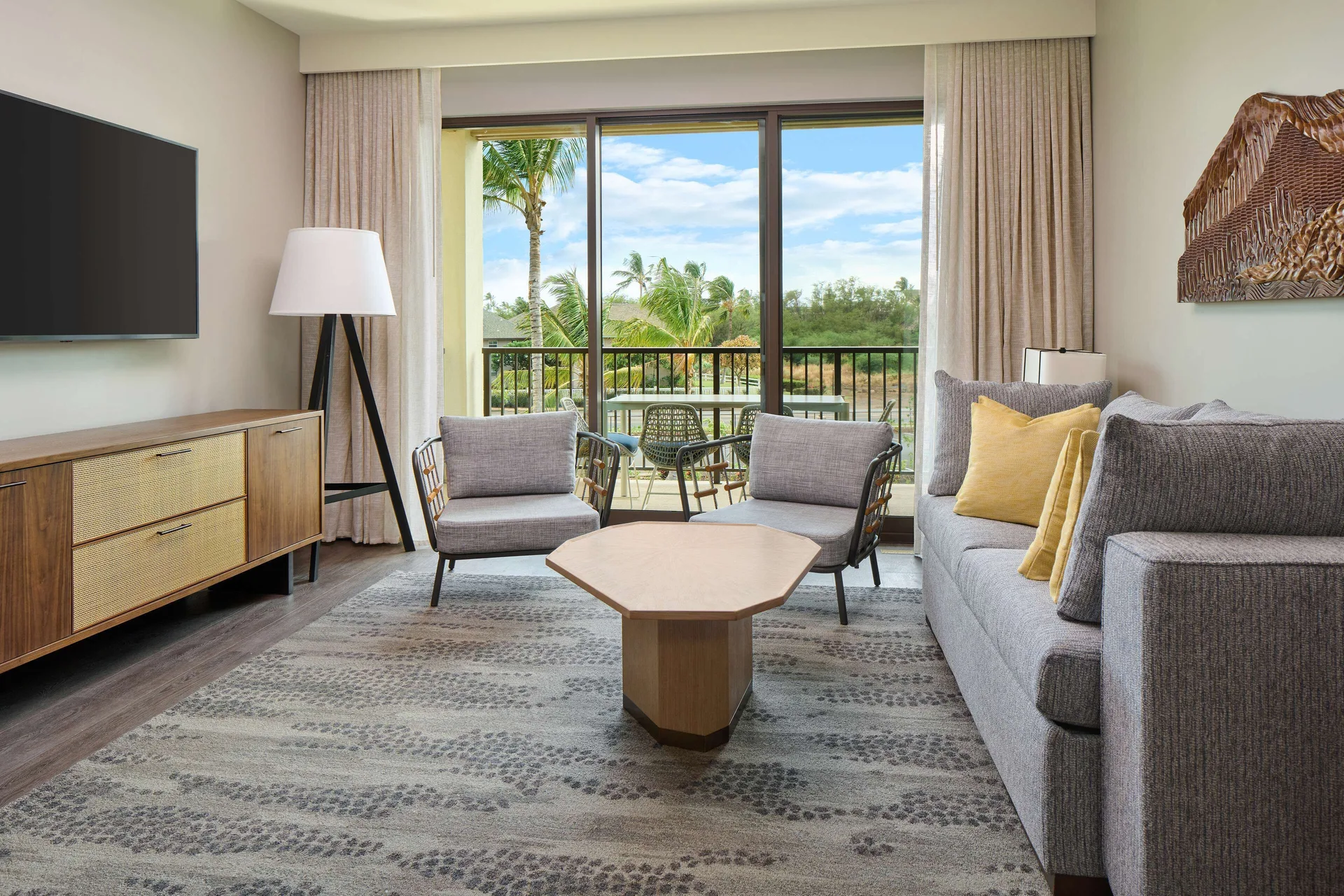 Living room with balcony and resort view at Hilton Grand Vacations Club Maui Bay Villas.