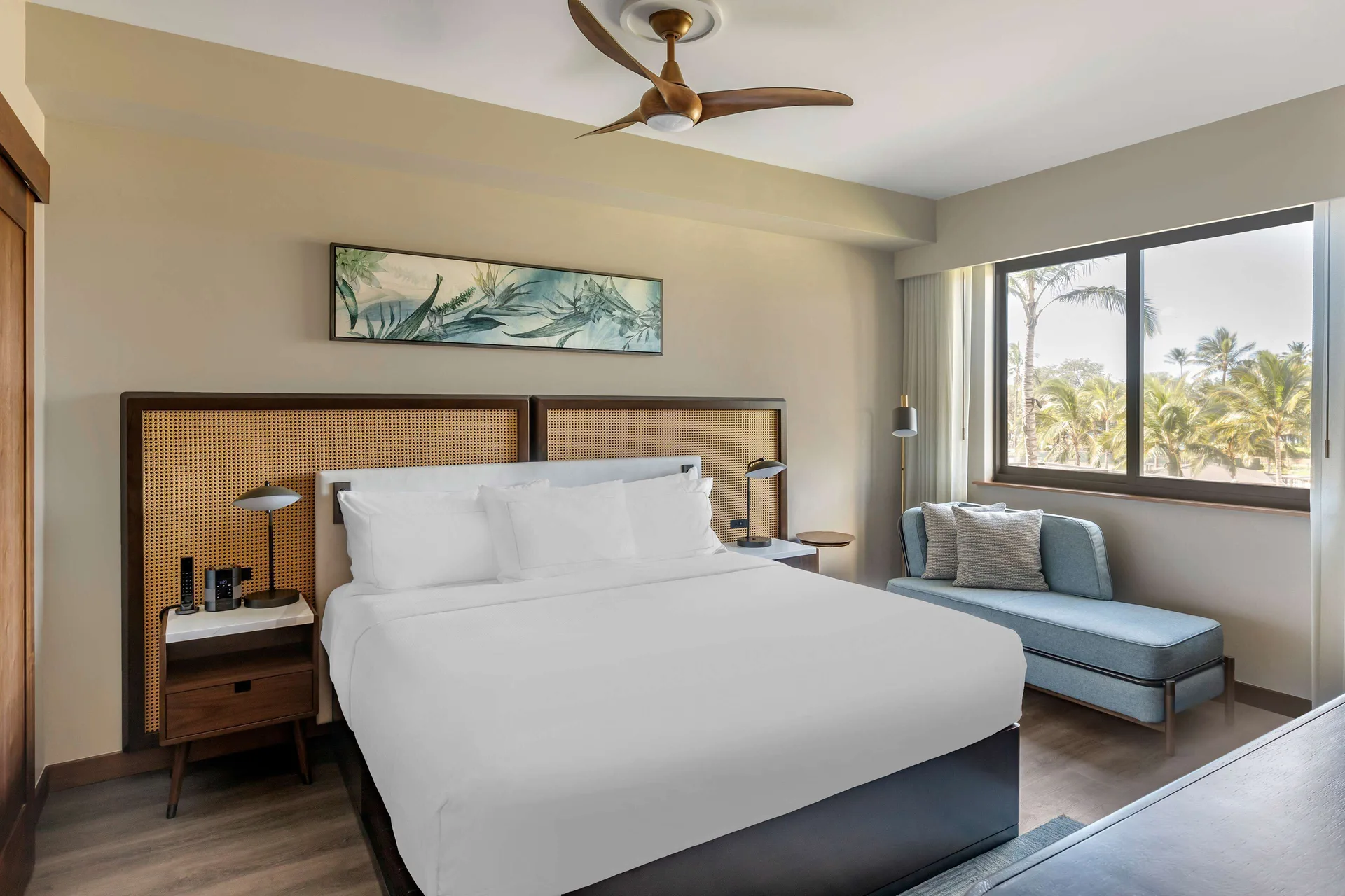 One-bedroom suite king bed and chaise by the window at Hilton Grand Vacations Club Maui Bay Villas.