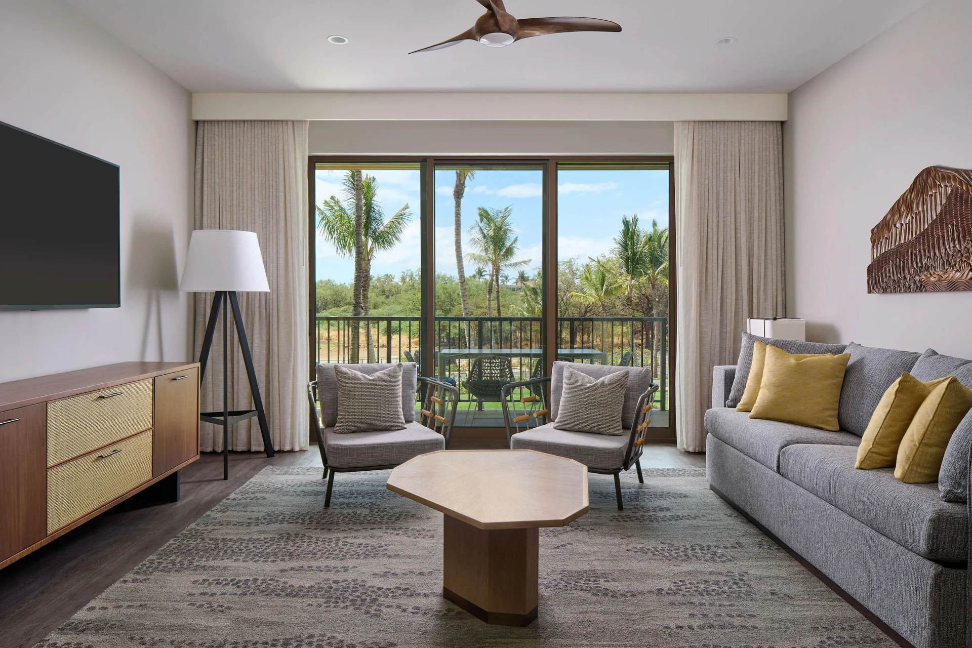 Resort view living room and balcony at Hilton Grand Vacations Club Maui Bay Villas.