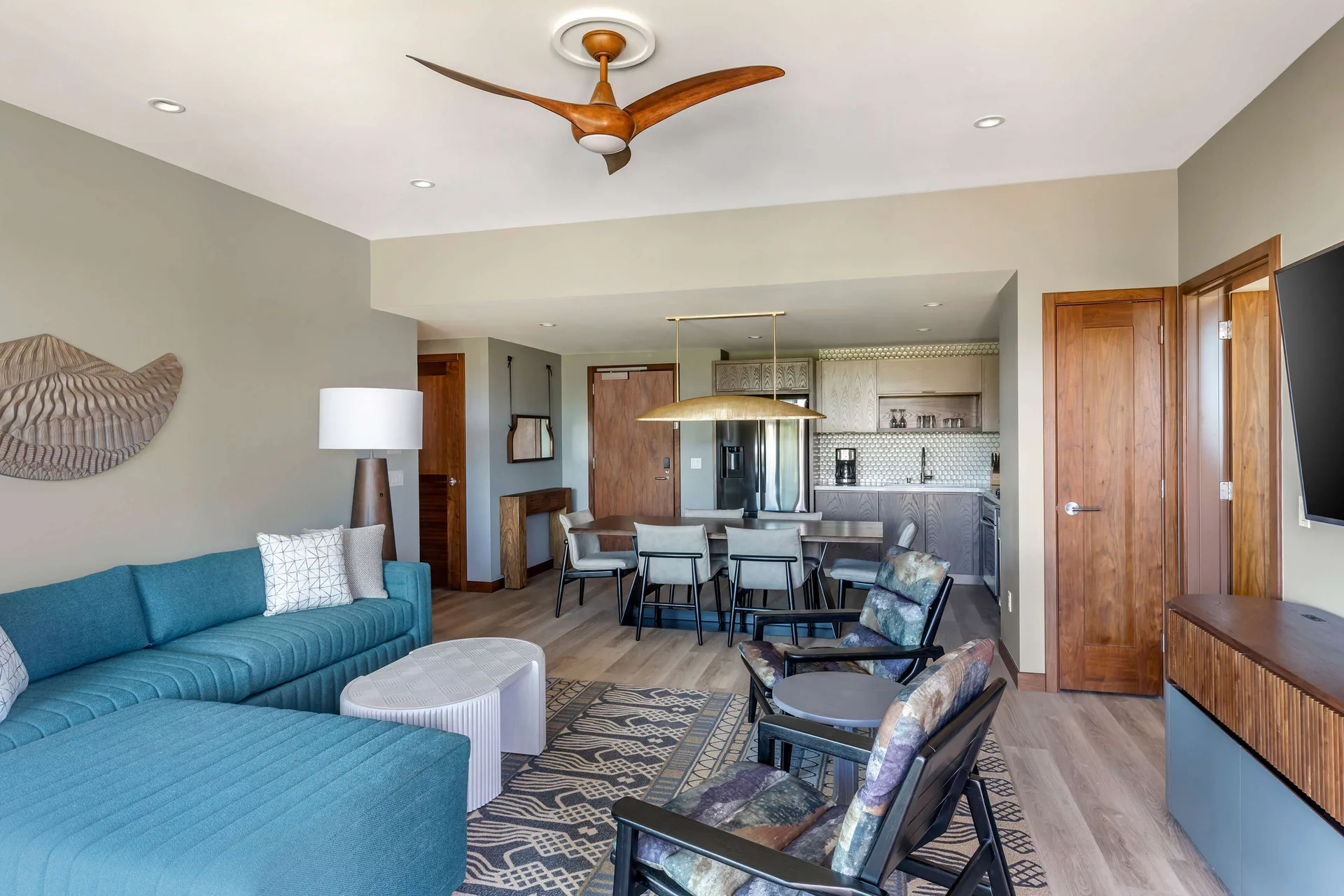 Open living area with sofa, lounge chairs, dining table, and kitchen at Hilton Grand Vacations Club Maui Bay Villas.