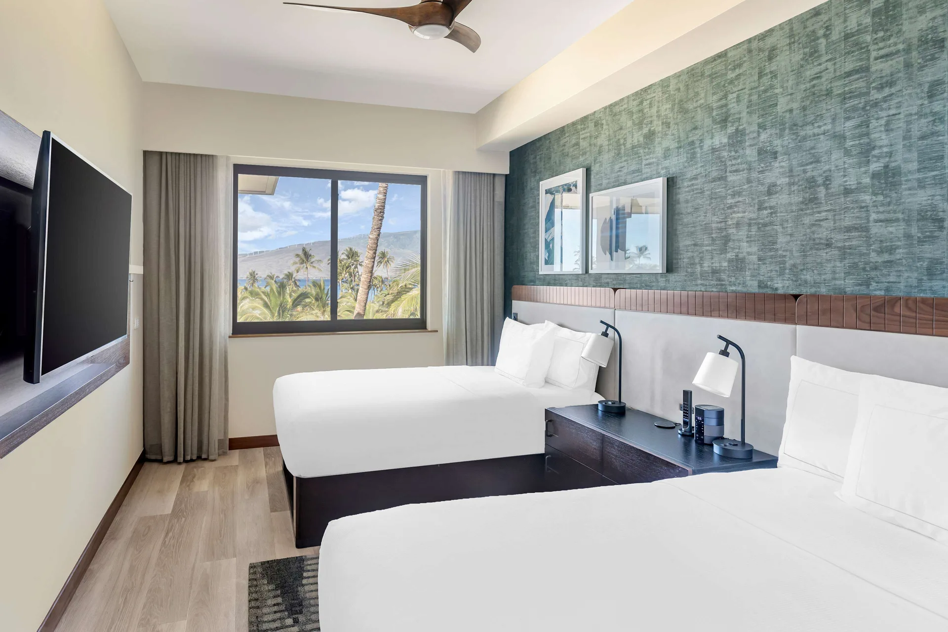Two-bed guest room with ocean and palm view at Hilton Grand Vacations Club Maui Bay Villas.