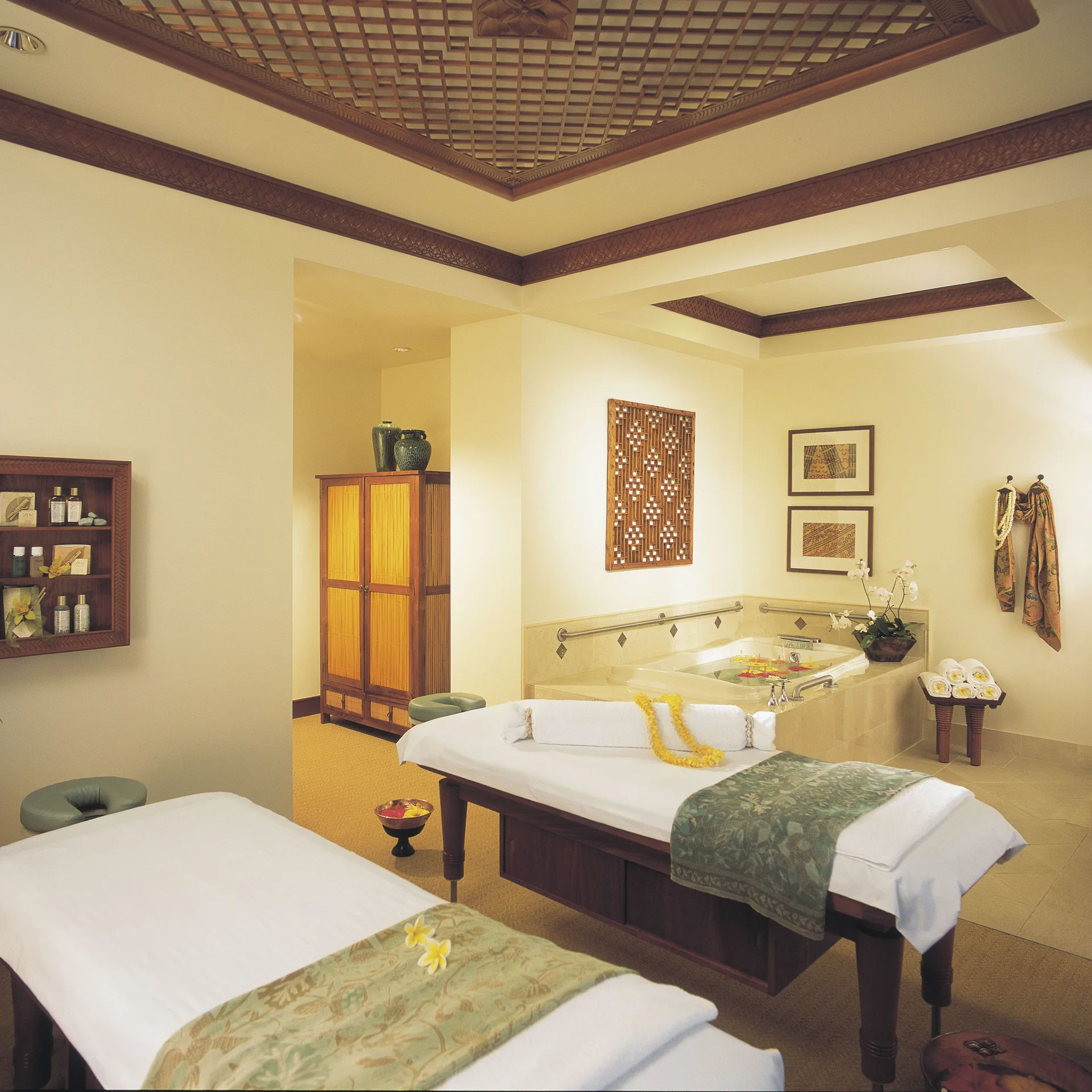 Spa treatment room with massage tables and a soaking tub at Hilton Hawaiian Village Waikiki Beach Resort.