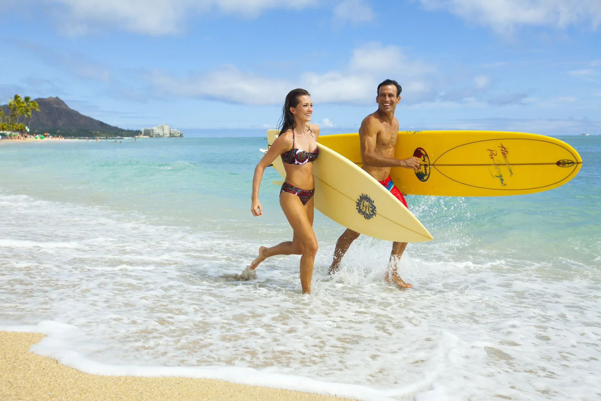 Surfers carrying boards from the Waikiki surf at Hilton Hawaiian Village Waikiki Beach Resort.