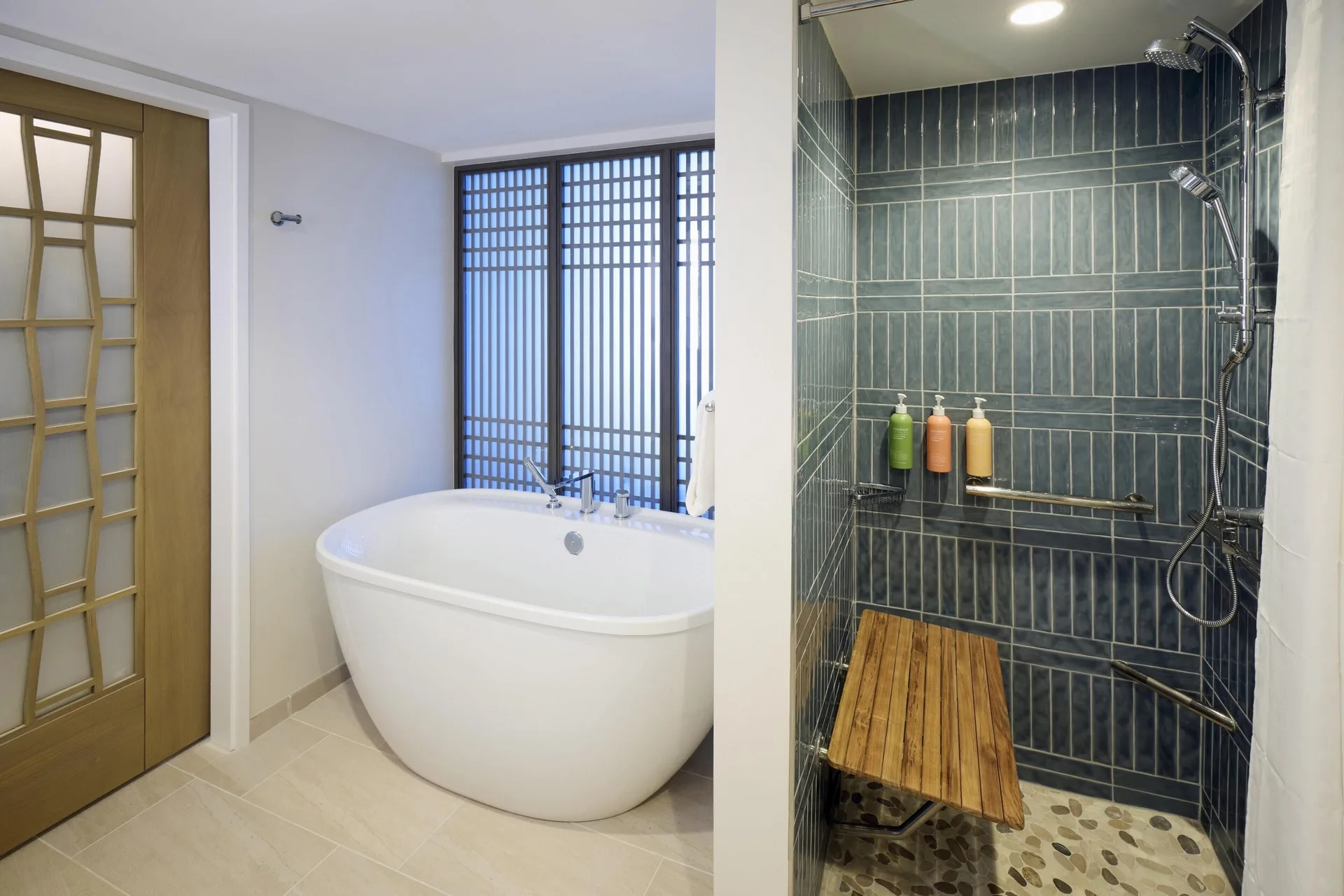 Accessible ocean view bathroom with tub and roll-in shower at Hilton Hawaiian Village Waikiki Beach Resort.