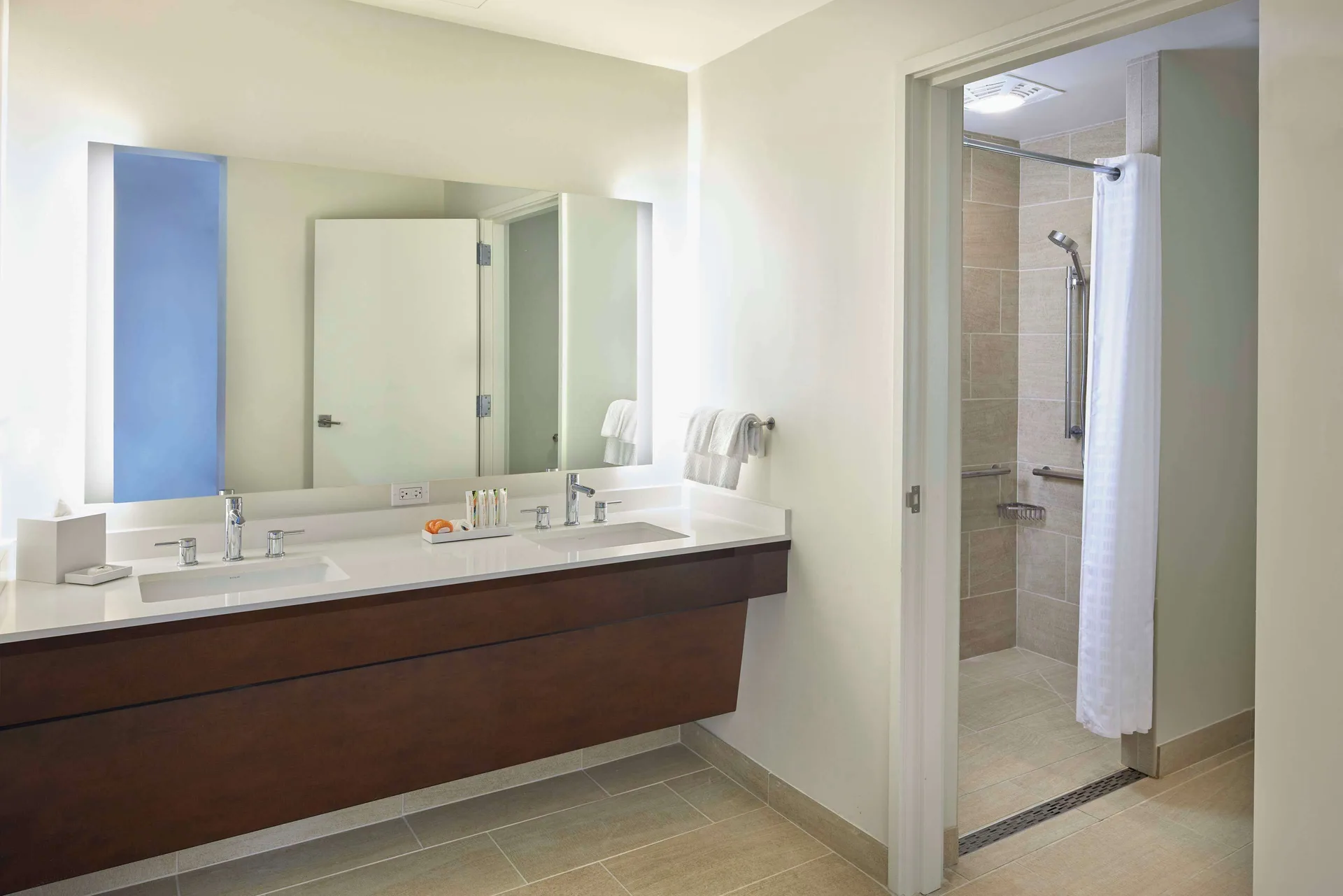 Accessible bathroom with double vanity and roll-in shower at Hilton Hawaiian Village Waikiki Beach Resort.