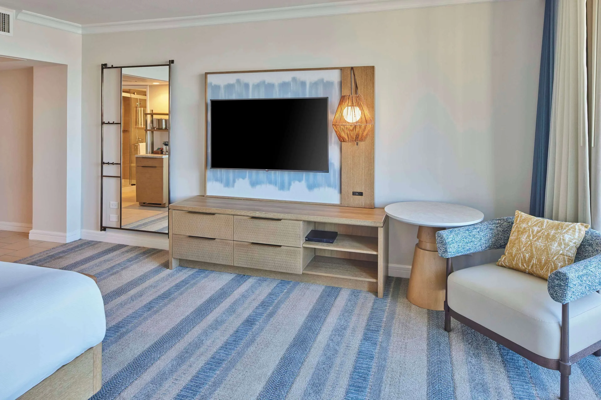 Ocean View room TV area and lounge chair at Hilton Hawaiian Village Waikiki Beach Resort.