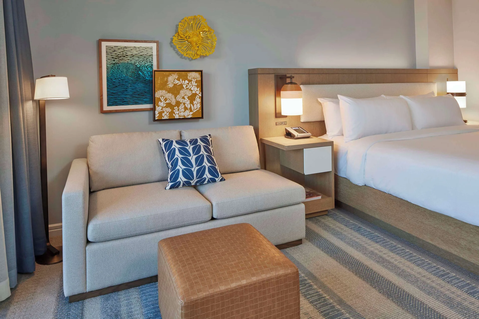 Renovated Ocean View room seating and king bed at Hilton Hawaiian Village Waikiki Beach Resort.