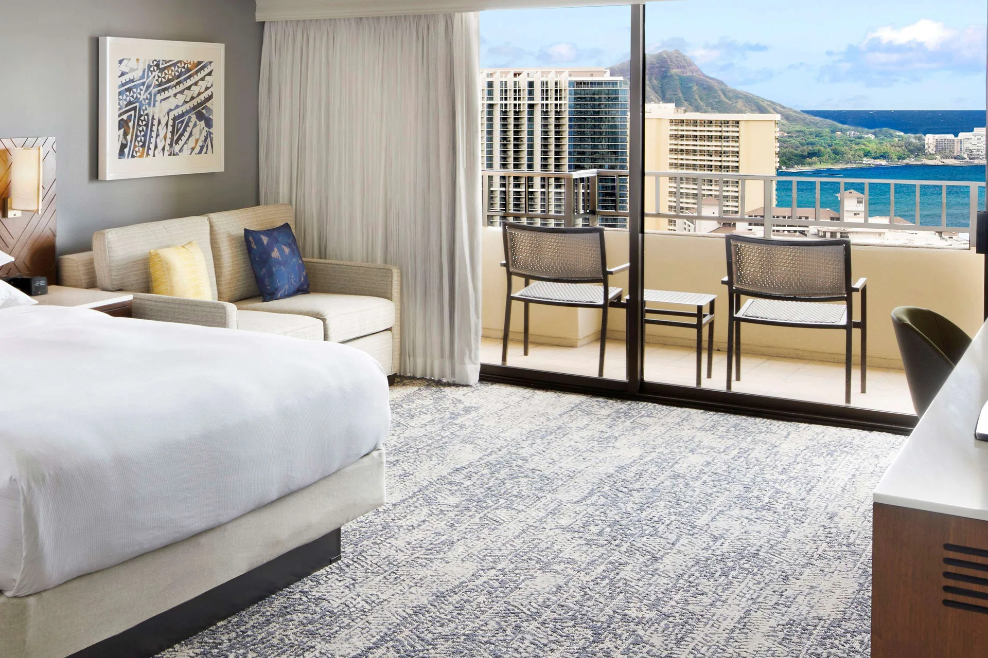 Ocean view Tapa Collection room with king bed and balcony at Hilton Hawaiian Village Waikiki Beach Resort.