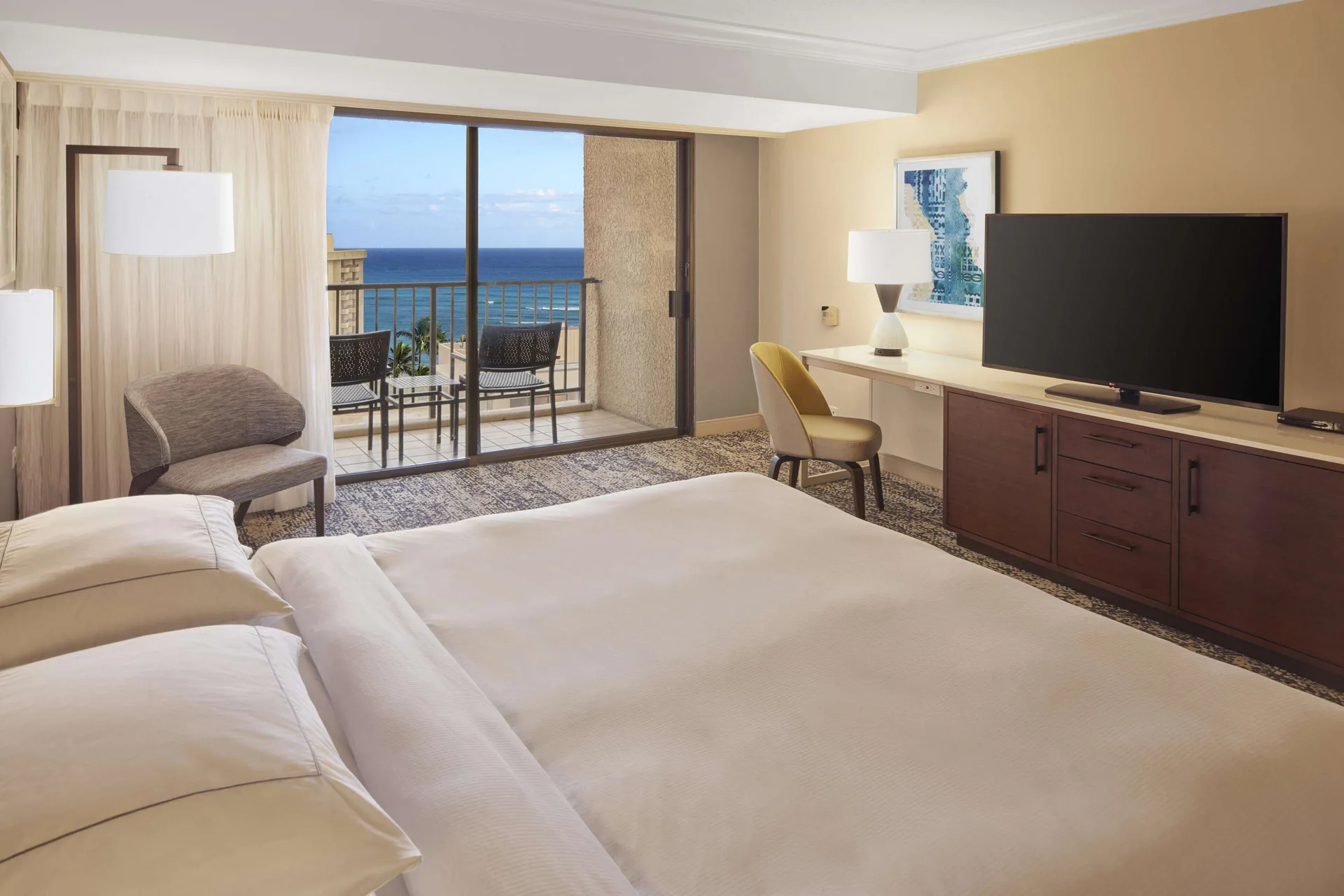 King-bed Tapa Collection room with TV, desk, balcony, and ocean view at Hilton Hawaiian Village Waikiki Beach Resort.