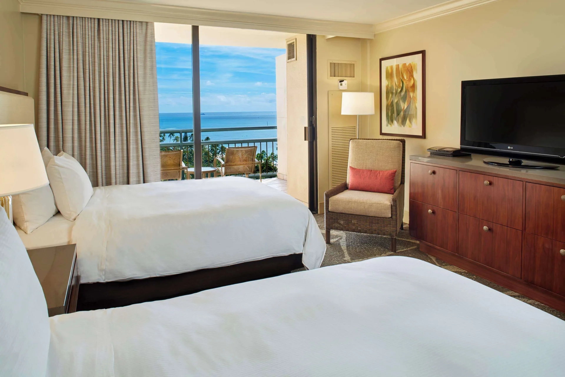 Two-bed ocean view room with balcony and dresser at Hilton Hawaiian Village Waikiki Beach Resort.