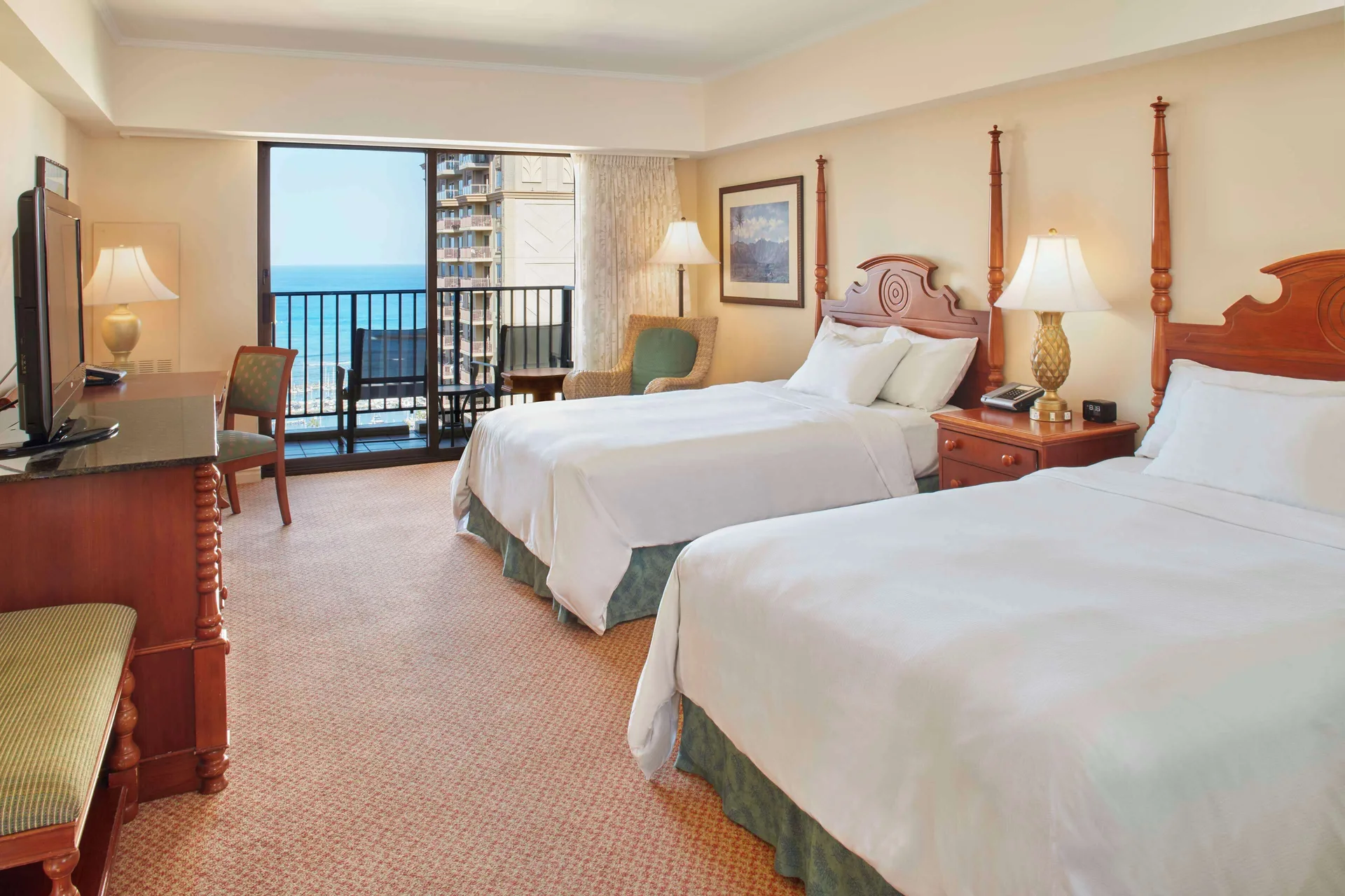 Two-bed ocean view room with balcony and classic wood furniture at Hilton Hawaiian Village Waikiki Beach Resort.