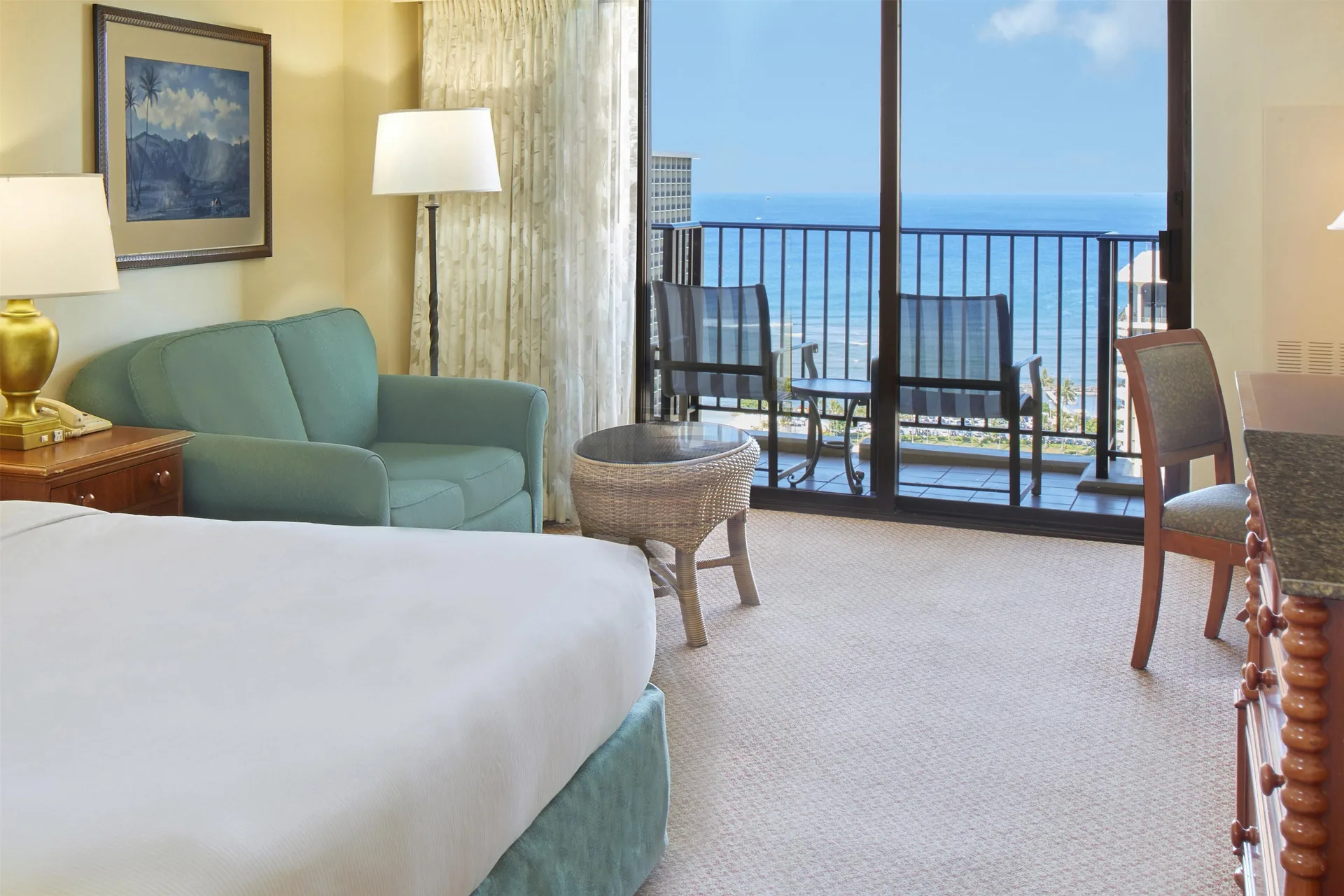Ocean view guest room with bed and balcony at Hilton Hawaiian Village Waikiki Beach Resort.
