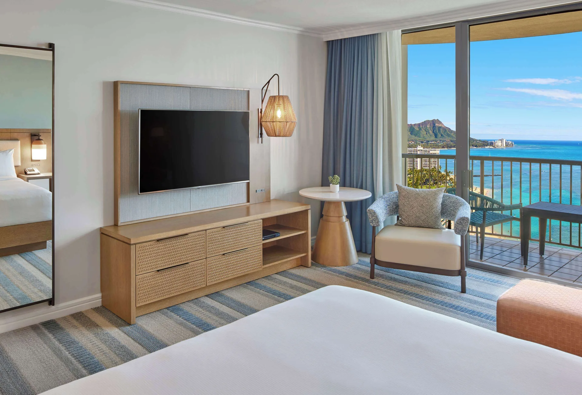 Rainbow Tower king room seating area and balcony view at Hilton Hawaiian Village Waikiki Beach Resort.
