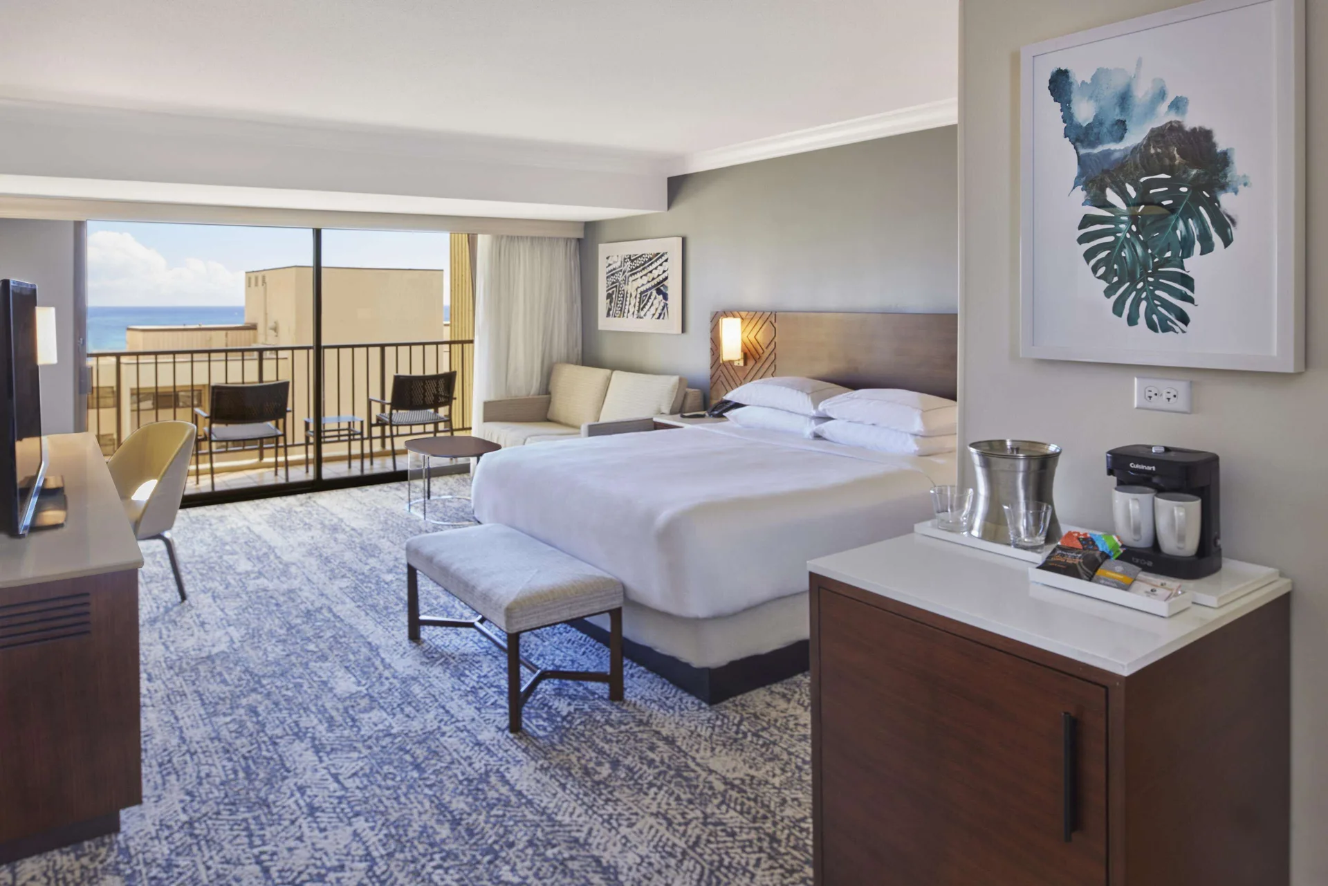 King resort view room with balcony and ocean glimpse at Hilton Hawaiian Village Waikiki Beach Resort.