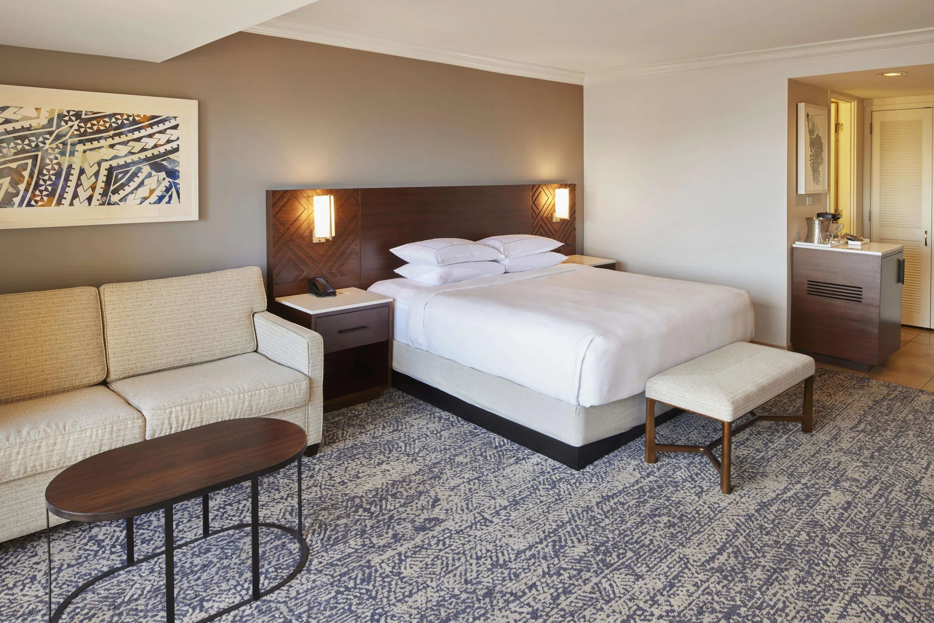 King room with sofa, bench, and coffee table at Hilton Hawaiian Village Waikiki Beach Resort.