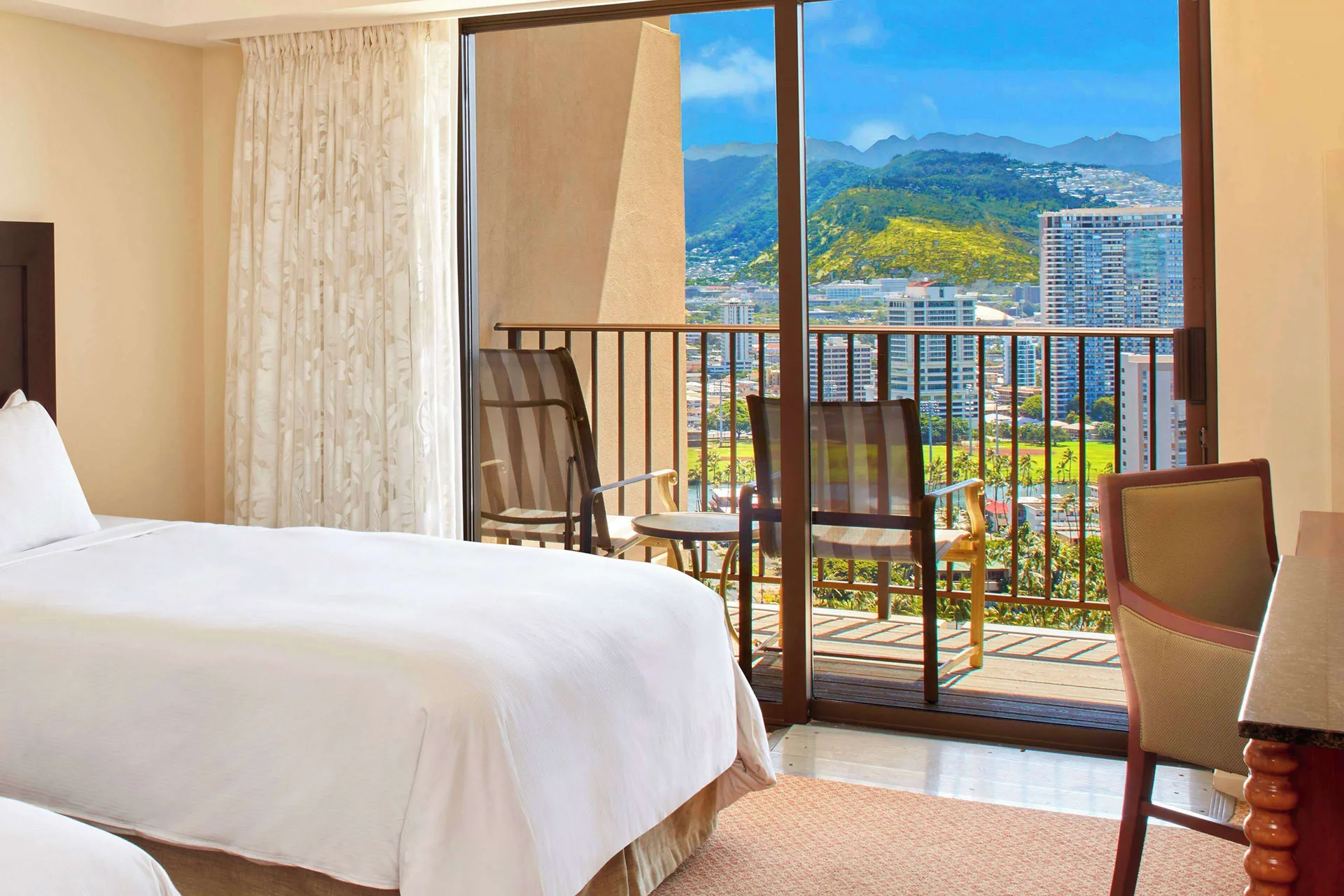 Bright resort view room with bed and balcony at Hilton Hawaiian Village Waikiki Beach Resort.