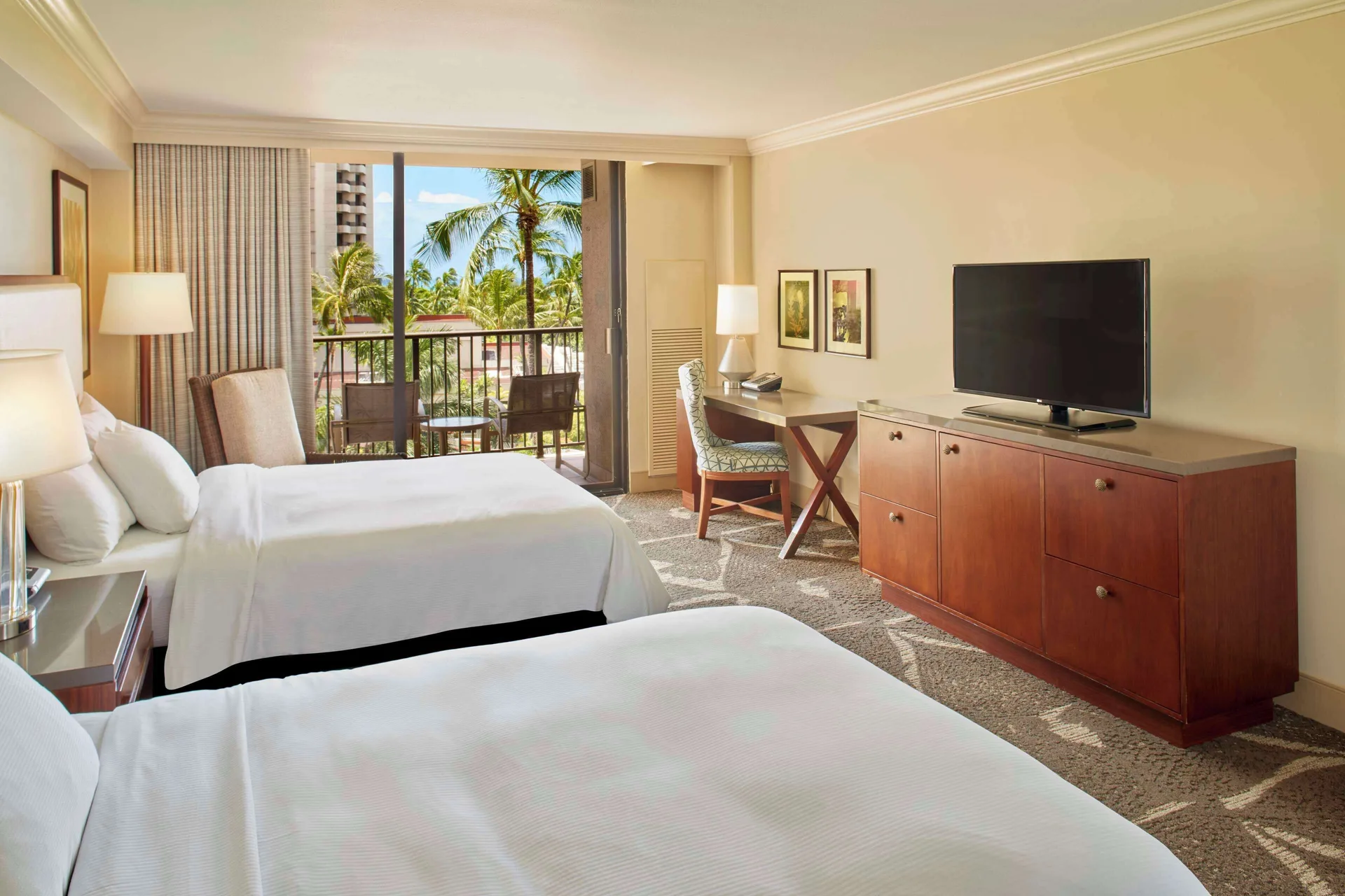 Two-bed room with TV, desk, and palm-view balcony at Hilton Hawaiian Village Waikiki Beach Resort.