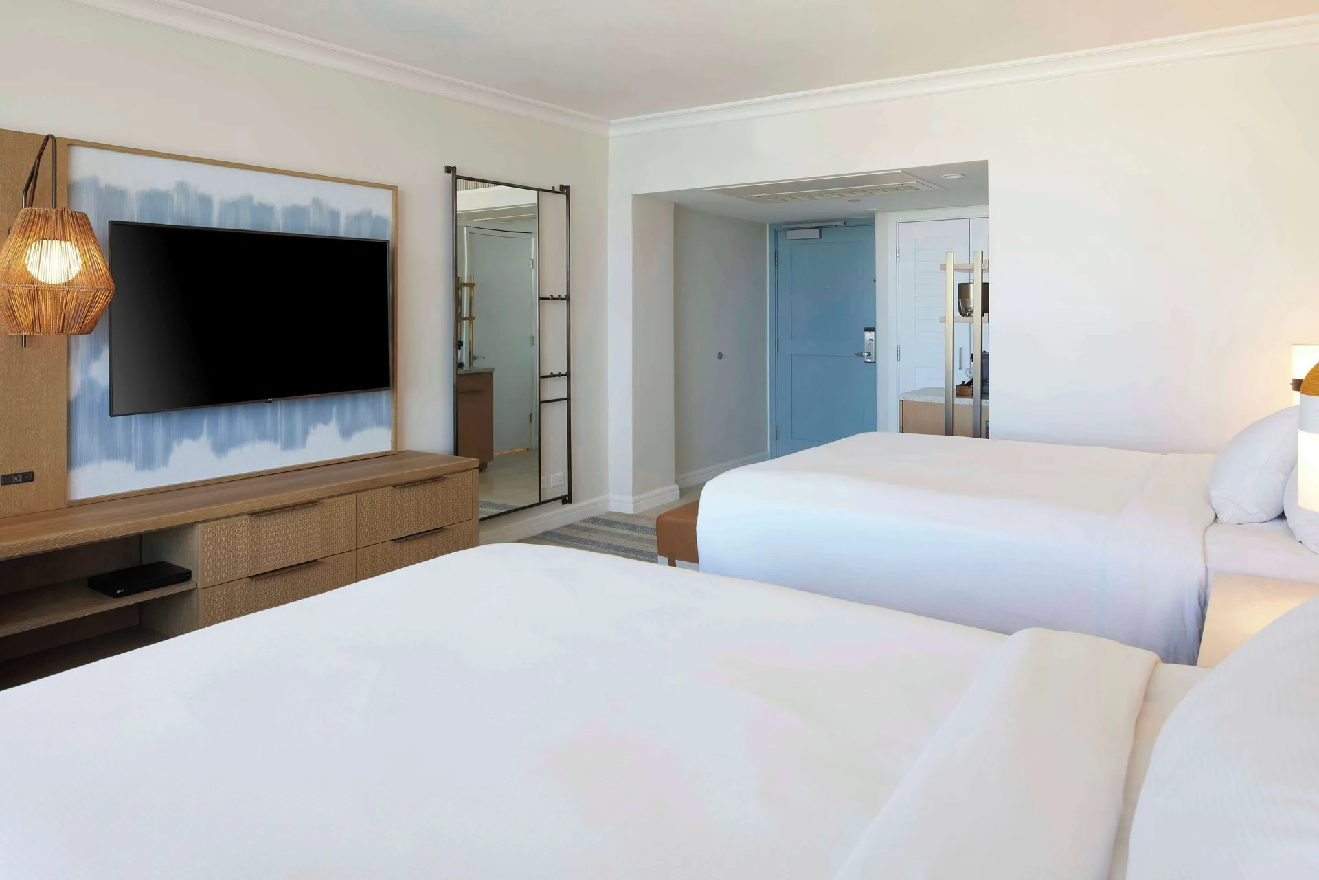 Two-bed resort view guest room at Hilton Hawaiian Village Waikiki Beach Resort with TV and entry area.
