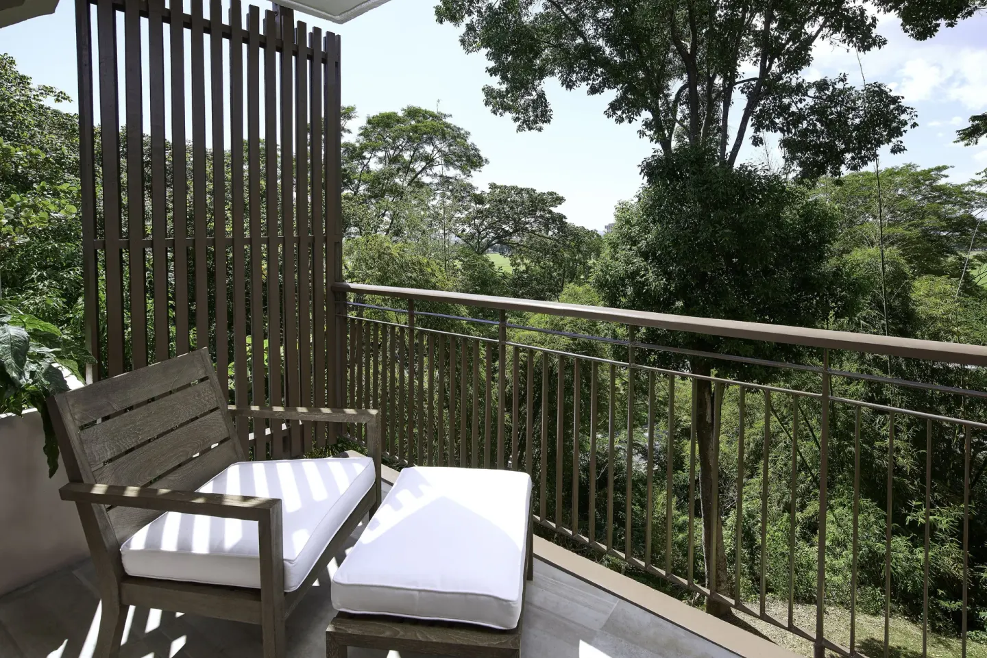 Balcony seating overlooking trees at Hilton Trinidad & Conference Centre.