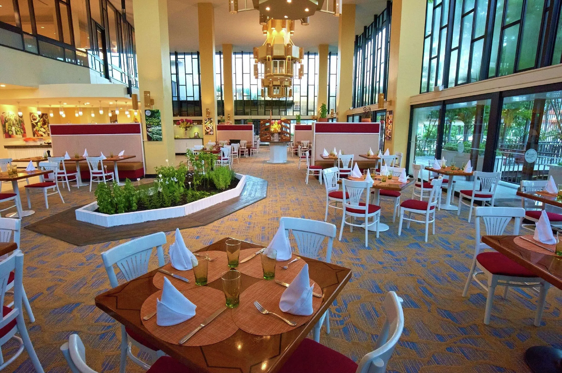 Restaurant tables beside tall windows at Hilton Trinidad & Conference Centre.