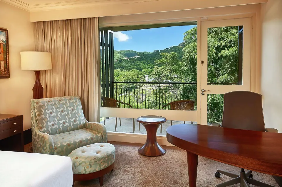 Deluxe Room sitting area and balcony view at Hilton Trinidad & Conference Centre.