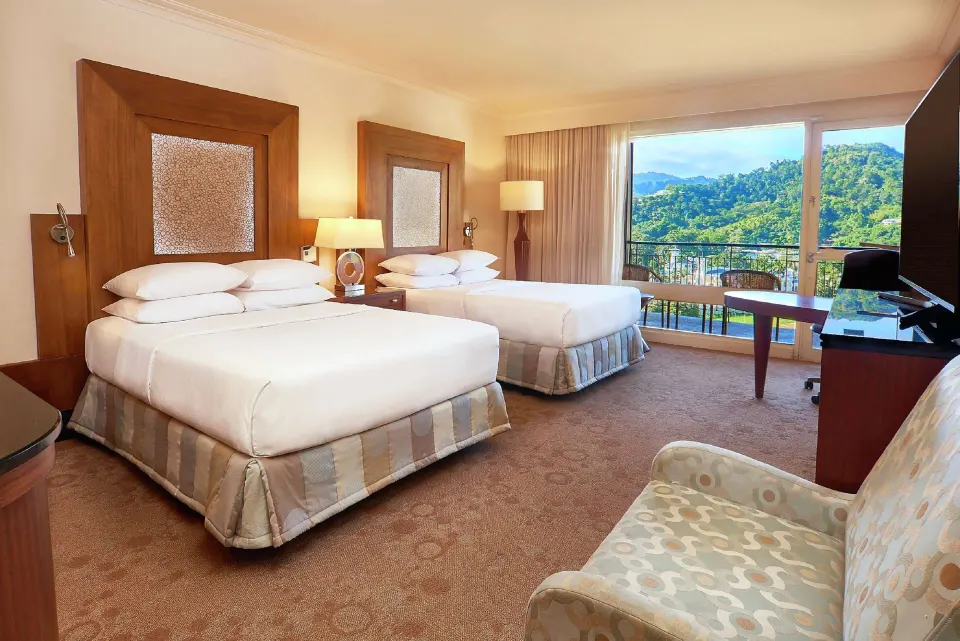 Deluxe Room with two beds and balcony view at Hilton Trinidad & Conference Centre.