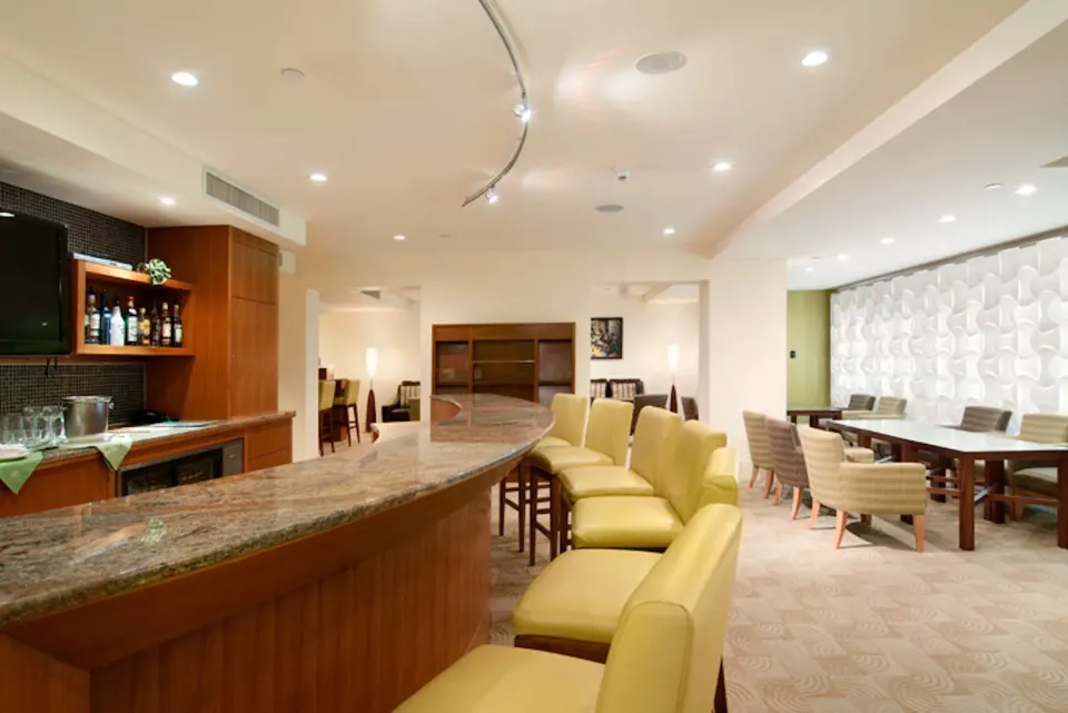 Private lounge bar with counter seating and dining tables at Hilton Trinidad & Conference Centre.