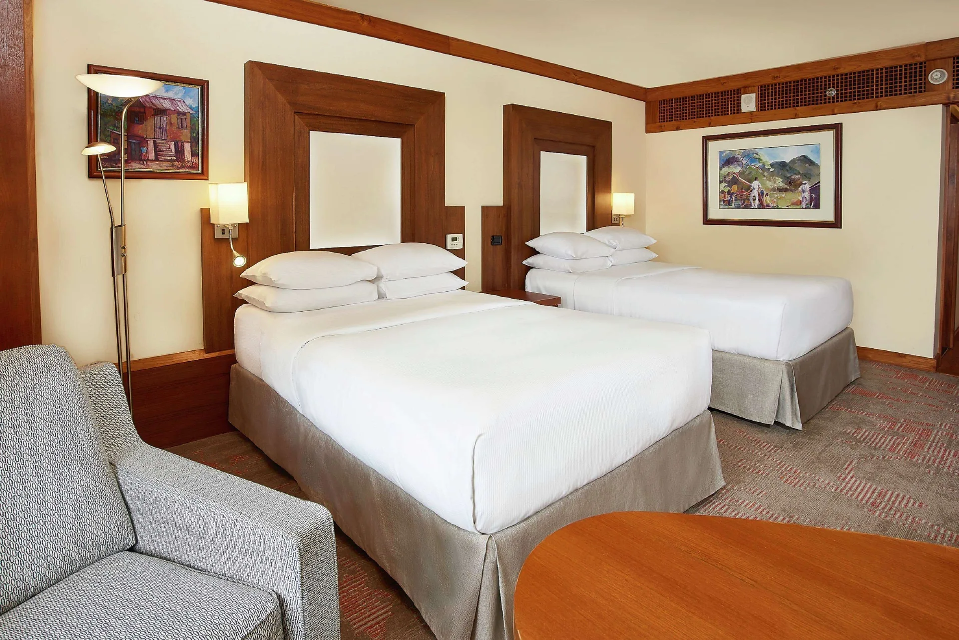 Two double beds in a garden view room at Hilton Trinidad & Conference Centre.