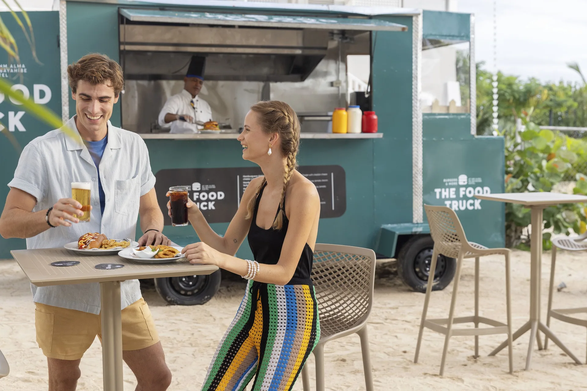 Guests enjoy drinks and snacks beside a food truck at HM Alma de Bayahibe.