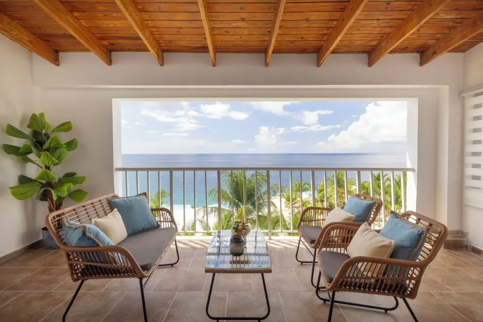Junior Suite sea view balcony with wicker seating at HM Alma de Bayahibe.