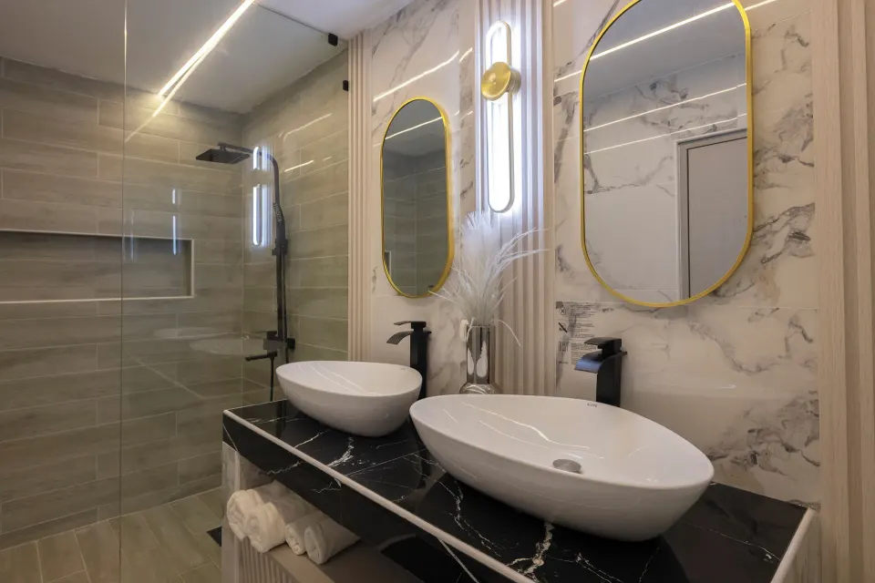Junior Suite sea view bathroom vanity with two basins and lit mirrors at HM Alma de Bayahibe.