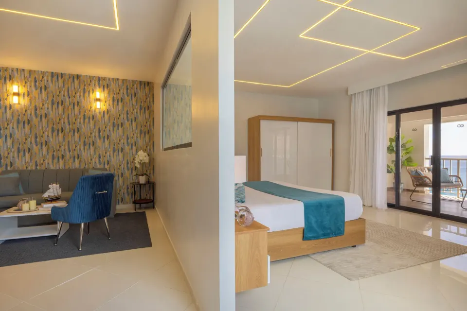 Junior Suite with king bed, lounge area and balcony doors at HM Alma de Bayahibe.