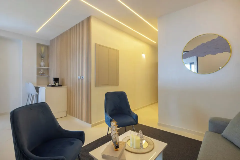 Junior Suite lounge with blue chairs, sofa and coffee station at HM Alma de Bayahibe.