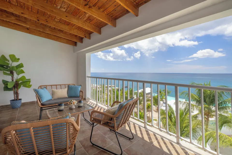 Junior Suite balcony with lounge chairs and ocean view at HM Alma de Bayahibe.