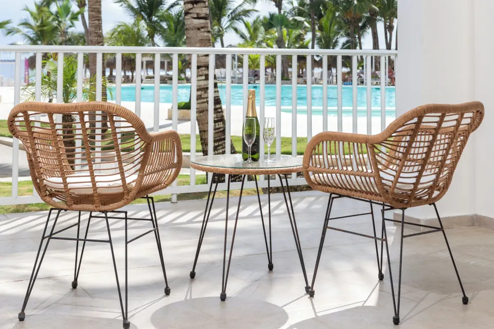 Junior Suite terrace seating with pool and palms at HM Alma de Bayahibe.
